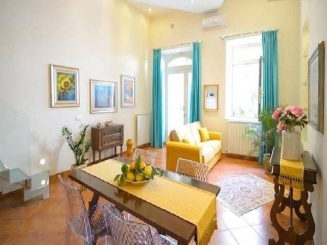 un soggiorno con tavolo e divano di Luxury Apartment Federica N 1 Centro Storico di Taormina a Taormina
