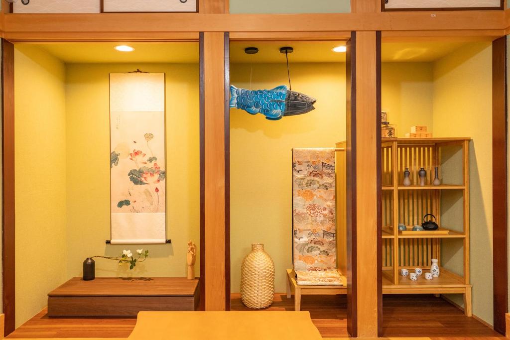 Japanese traditional house.Ryokan in asakusa with 2bedrooms في طوكيو: غرفة بجدران صفراء وطاولة ورف