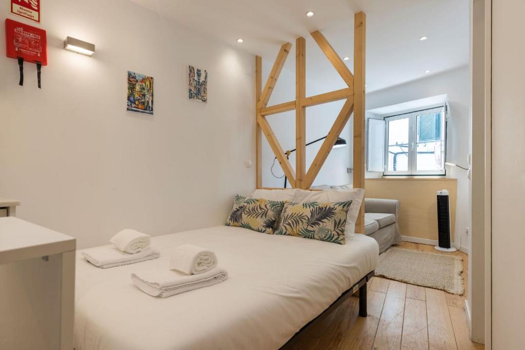 - une petite chambre avec un lit blanc et une fenêtre dans l'établissement Alfama's Heart Studio by LovelyStay, à Lisbonne