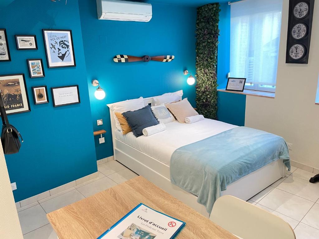 um quarto com uma cama e uma parede azul em ☆ Les pieds sur terre ☆ tout confort ☆ NETFLIX ☆ em Metz