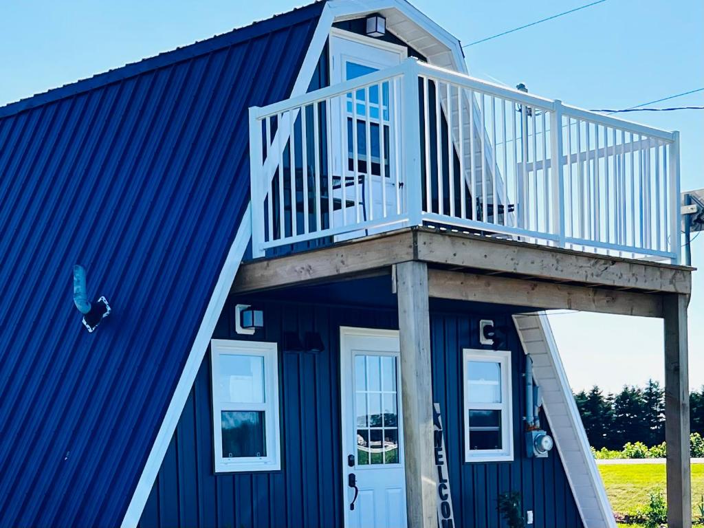 a blue house with a deck on top of it at Serendib by St Peters Bay in Saint Peters
