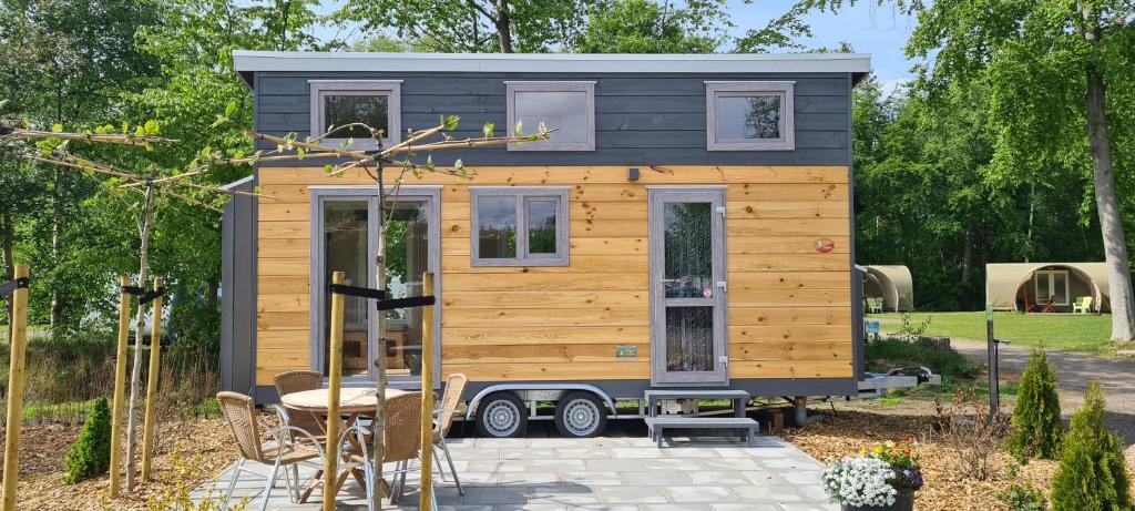 a tiny house on a trailer in a yard at Vakantiepark 't Urkerbos -Tiny house in Urk