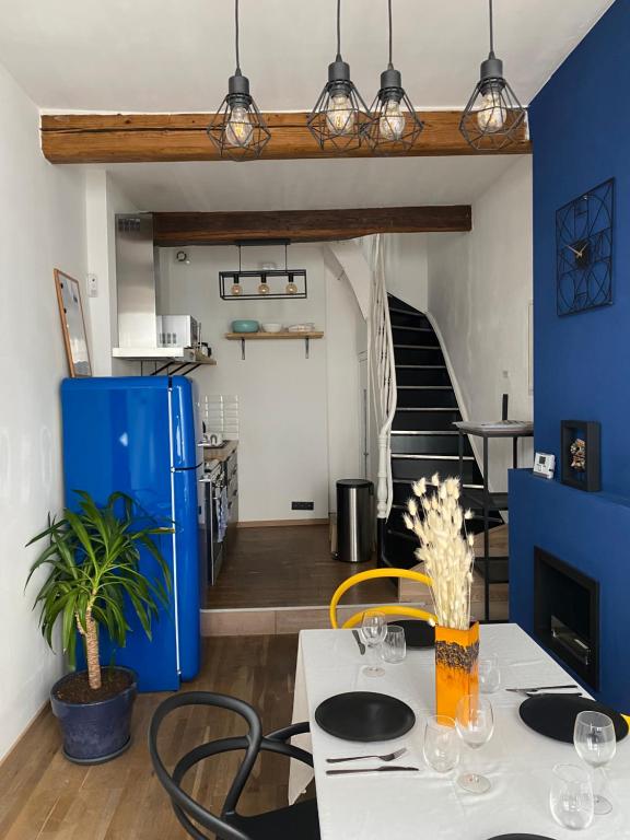 comedor con mesa y nevera azul en Vivegnis, little cosy house, en Lieja