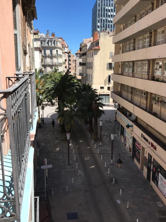 une rue dans une ville avec des palmiers et des bâtiments dans l'établissement 2 pièces Hyper Centre Équipé et Confortable Toulon, à Toulon