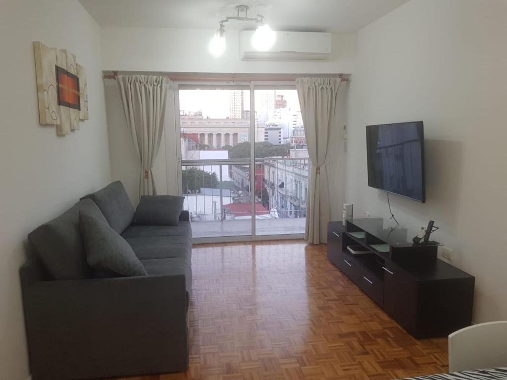 ein Wohnzimmer mit einem Sofa und einem Flachbild-TV in der Unterkunft Excelente departamento en el corazon de San Telmo in Buenos Aires