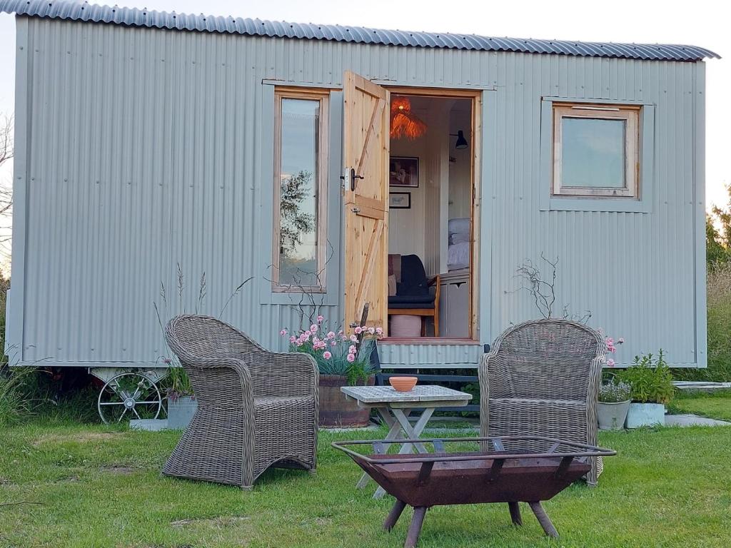 a small shed with two chairs and a table in the yard at Doris in Wedmore