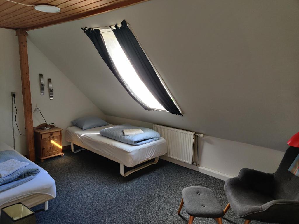 Habitación pequeña con 2 camas y ventana en Købmandsgaardens B&B en Gedser