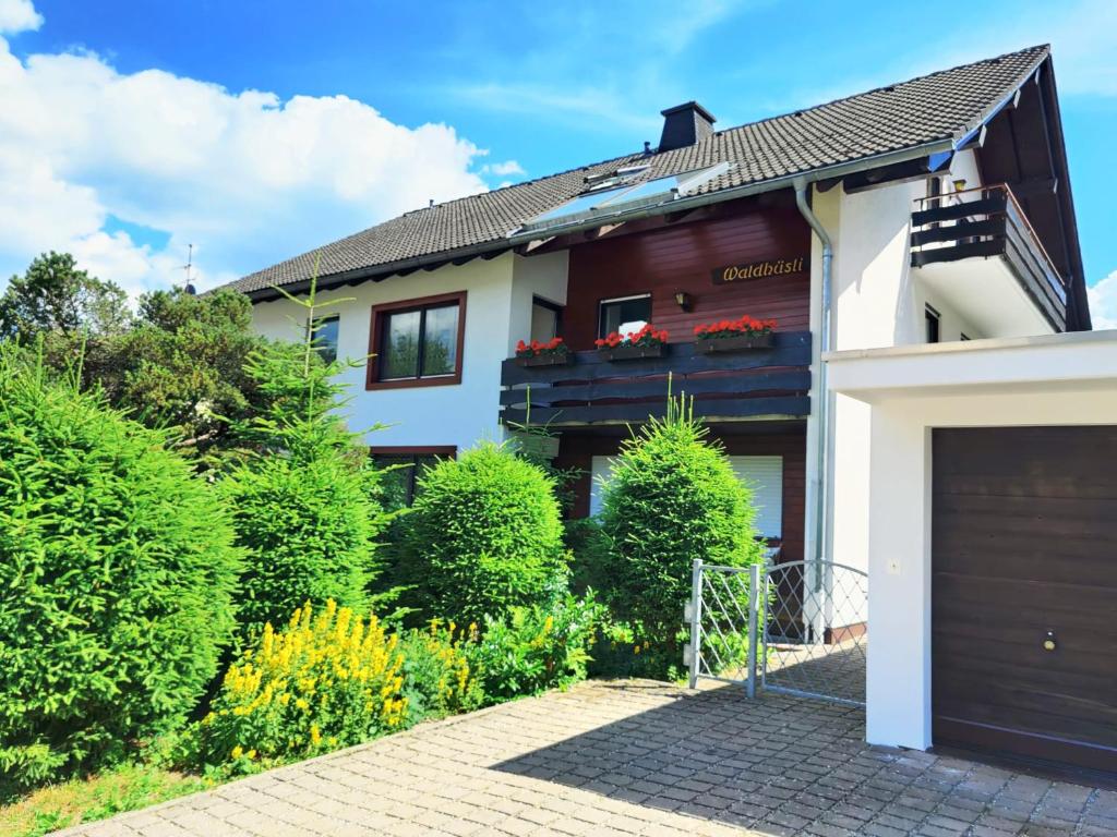 a house with a garage in front of it at Romantic Style Apartment Titisee in Titisee-Neustadt