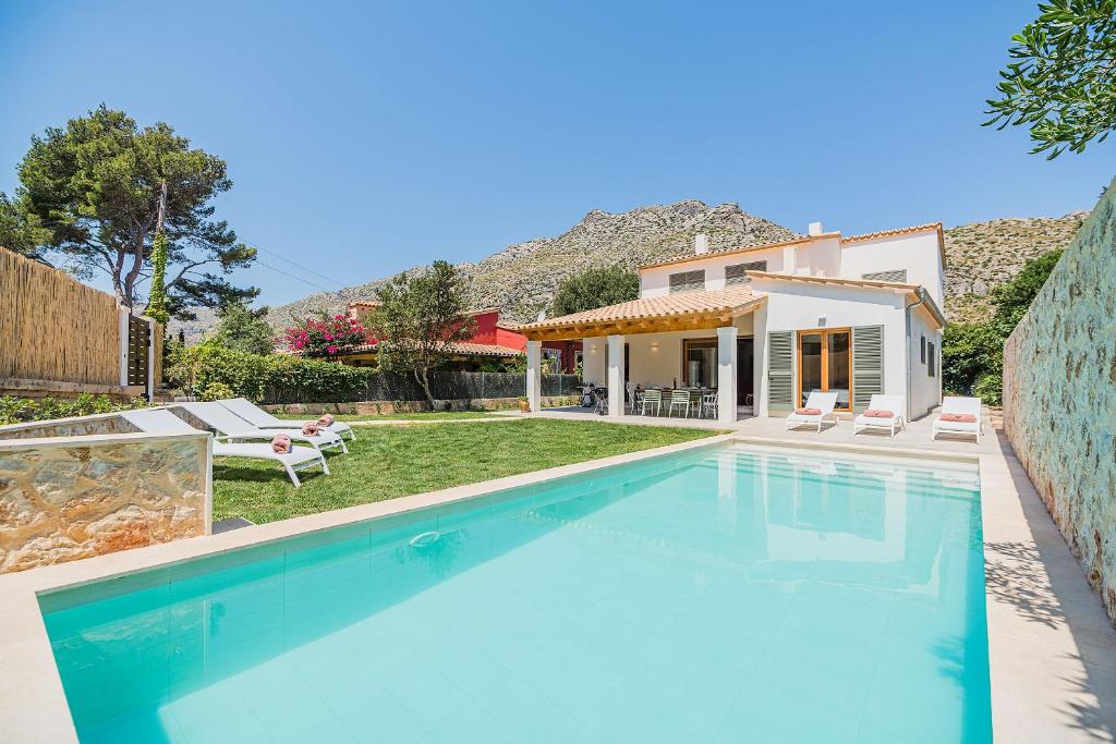 a villa with a swimming pool and a house at Villa Mar Clara By SunVillas Mallorca in Cala de Sant Vicent