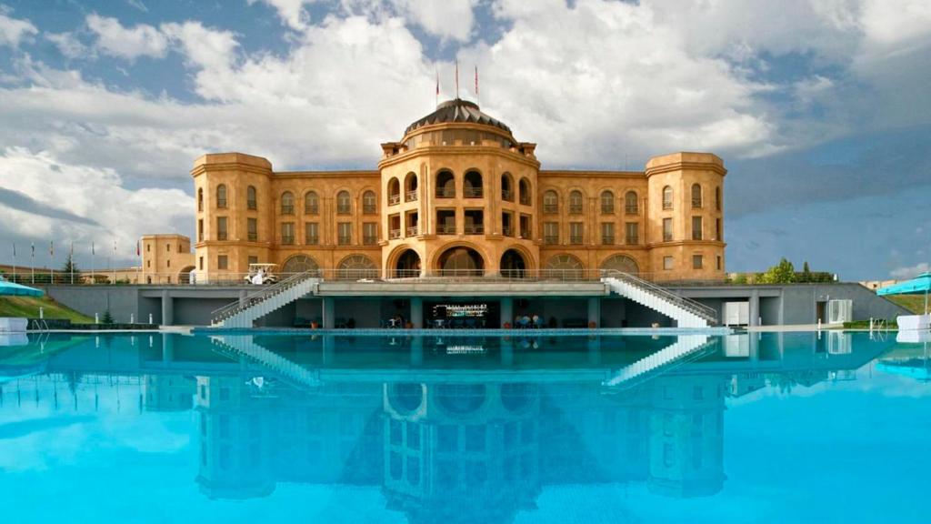 ein Gebäude mit einem Pool mit Wasser davor in der Unterkunft Latar Hotel Yerevan in Yerevan