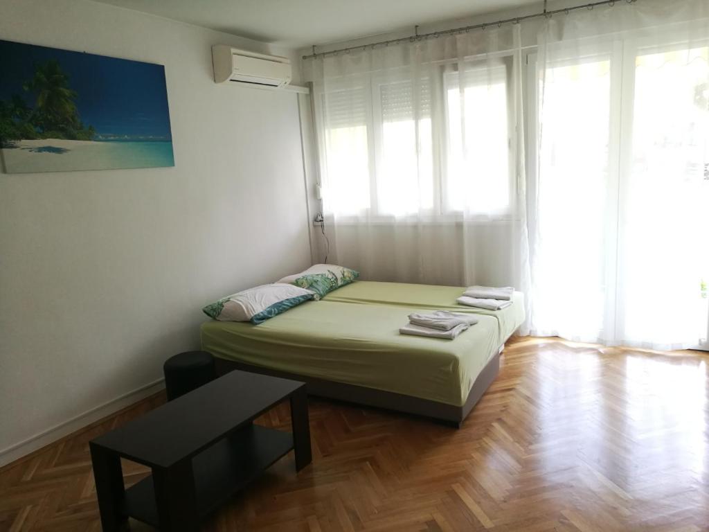 um quarto com uma cama, uma mesa e uma janela em Pretty big double bed room with balcony em Split