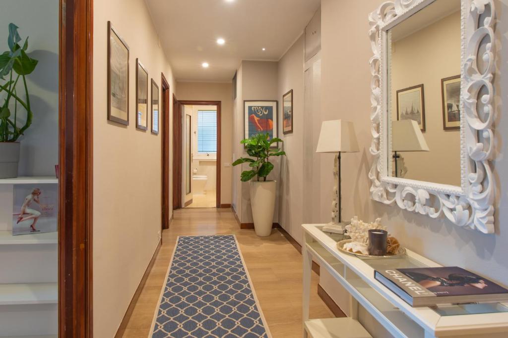 einen Flur mit einem blauen Teppich und einem Spiegel in der Unterkunft Home Terrace in Alassio