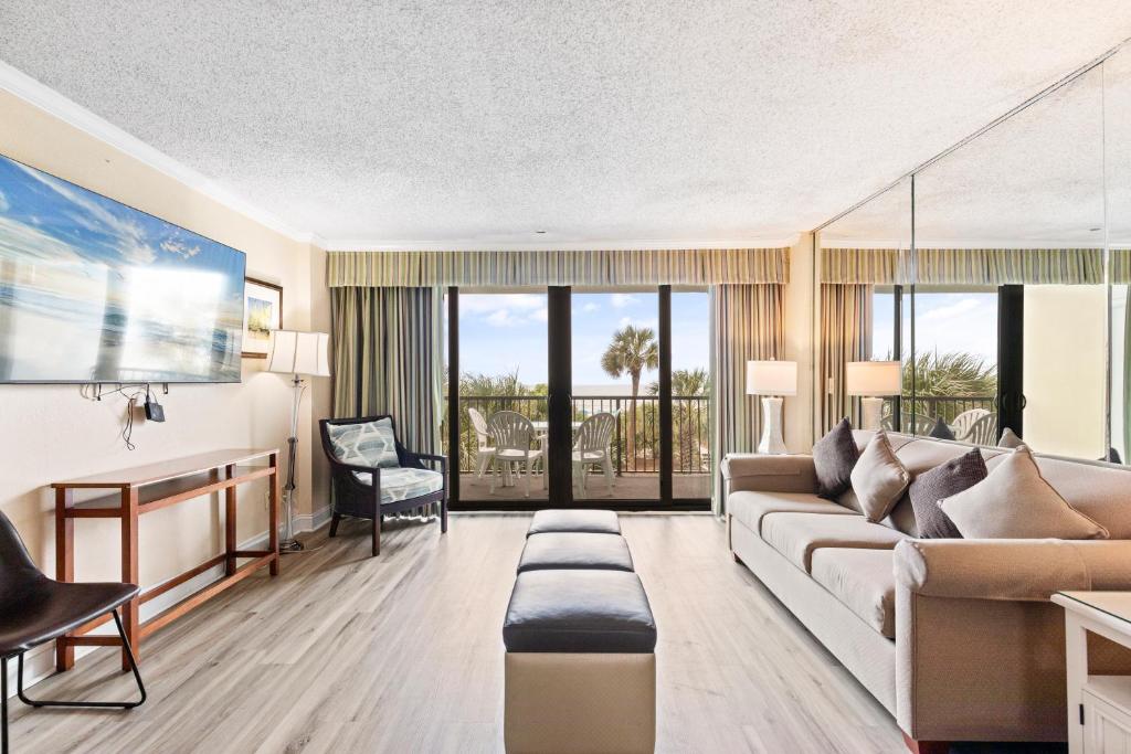 a living room with a couch and a table at 2-Bedroom Carolina Dunes Condo with Private Balcony and Ocean Views in Myrtle Beach