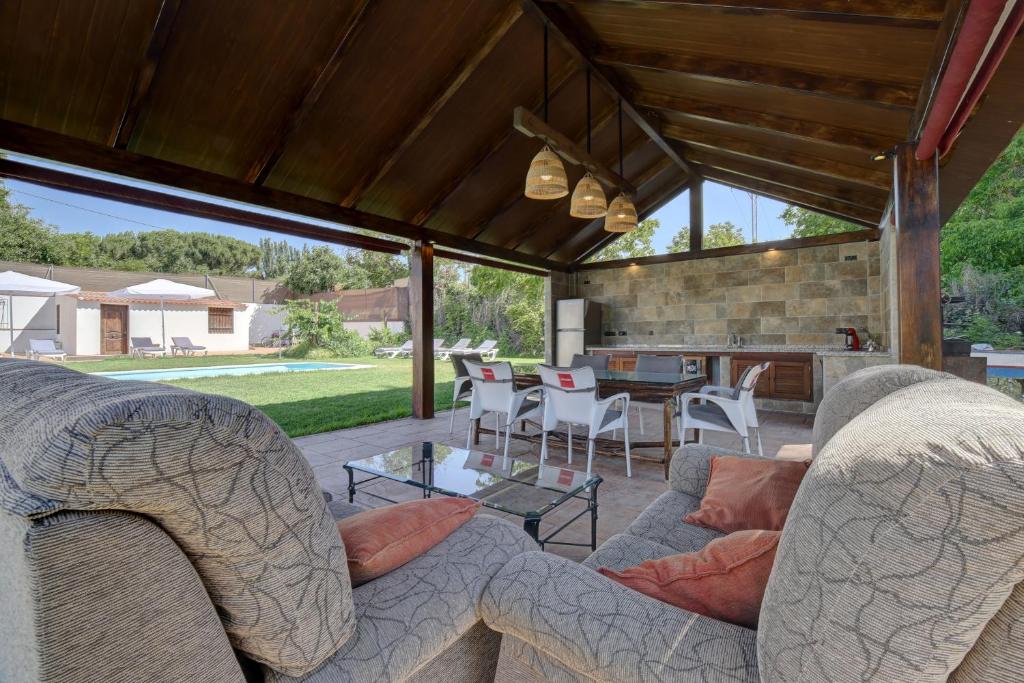 een patio met 2 banken en een tafel met stoelen bij Villa Carmen in Ronda