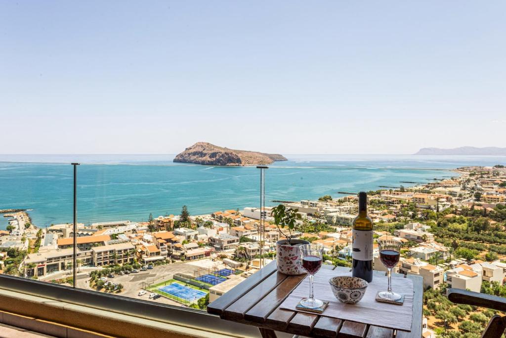 VenMar Luxury Holiday Home في بلاتانياس: طاولة مع كؤوس للنبيذ وإطلالة على المحيط