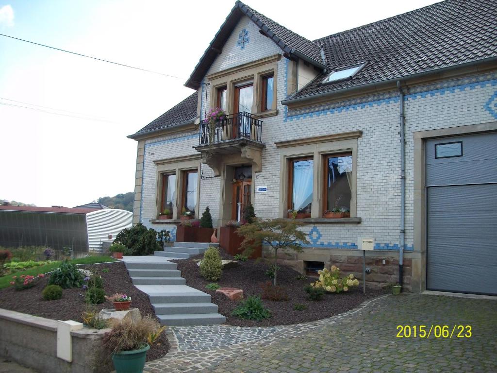 ein Haus mit einer blauen Tür und einer Einfahrt in der Unterkunft Chambres d hôtes du Stockgarten in Betting-lès-Saint-Avold