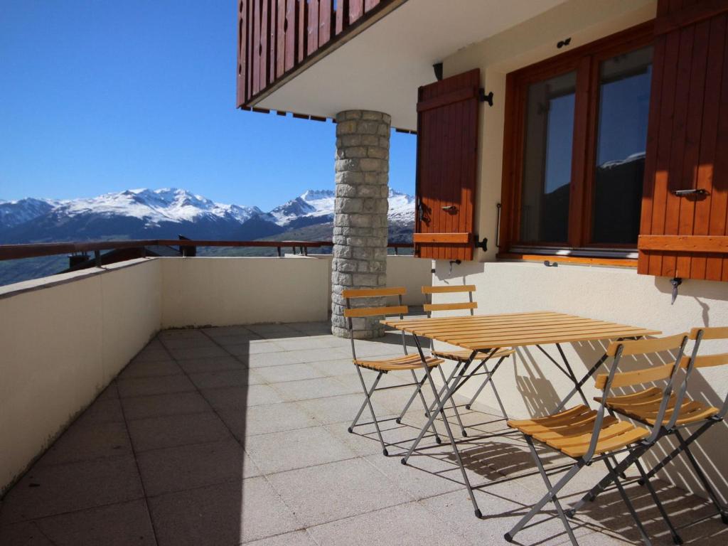 a patio with a table and chairs and mountains at Appartement Peisey-Vallandry, 3 pièces, 7 personnes - FR-1-411-166 in Landry