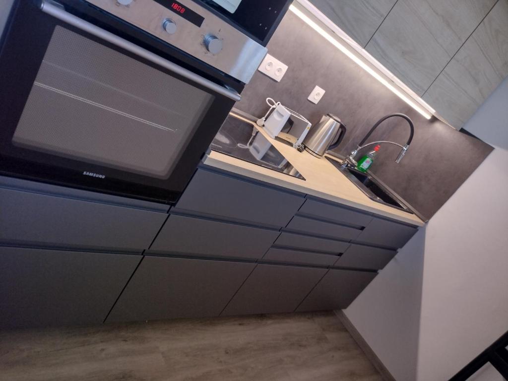 a kitchen with a sink and a stove at Kilátó Apartman in Tapolca