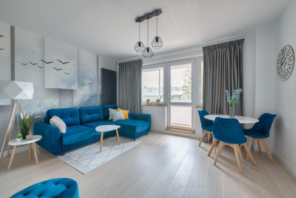 a living room with a blue couch and a table at Dom & House - Apartments Mauritius in Sopot