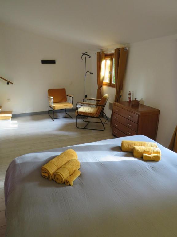 Un dormitorio con una cama con toallas amarillas. en Petit chalet cosy Sarlat en Sarlat-la-Canéda