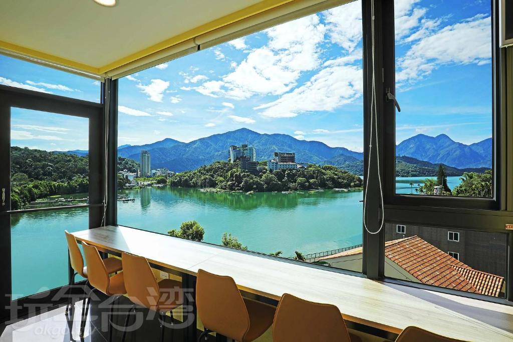 a conference room with a view of the water and mountains at Zhaohong homestay in Yuchi