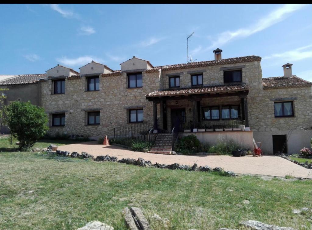 una gran casa de piedra con un patio delante en Encantadora Casa Rural: Las 7 Llaves, en Consuegra de Murera