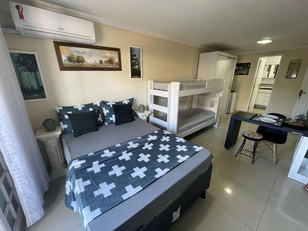 een slaapkamer met een bed en een stapelbed bij Central Praias Suíte 5 in Cabo Frio