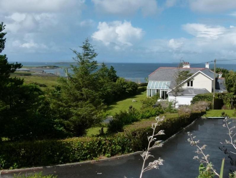 ein Haus und ein Fluss neben einem Haus in der Unterkunft Ocean Lodge B&B in Renvyle