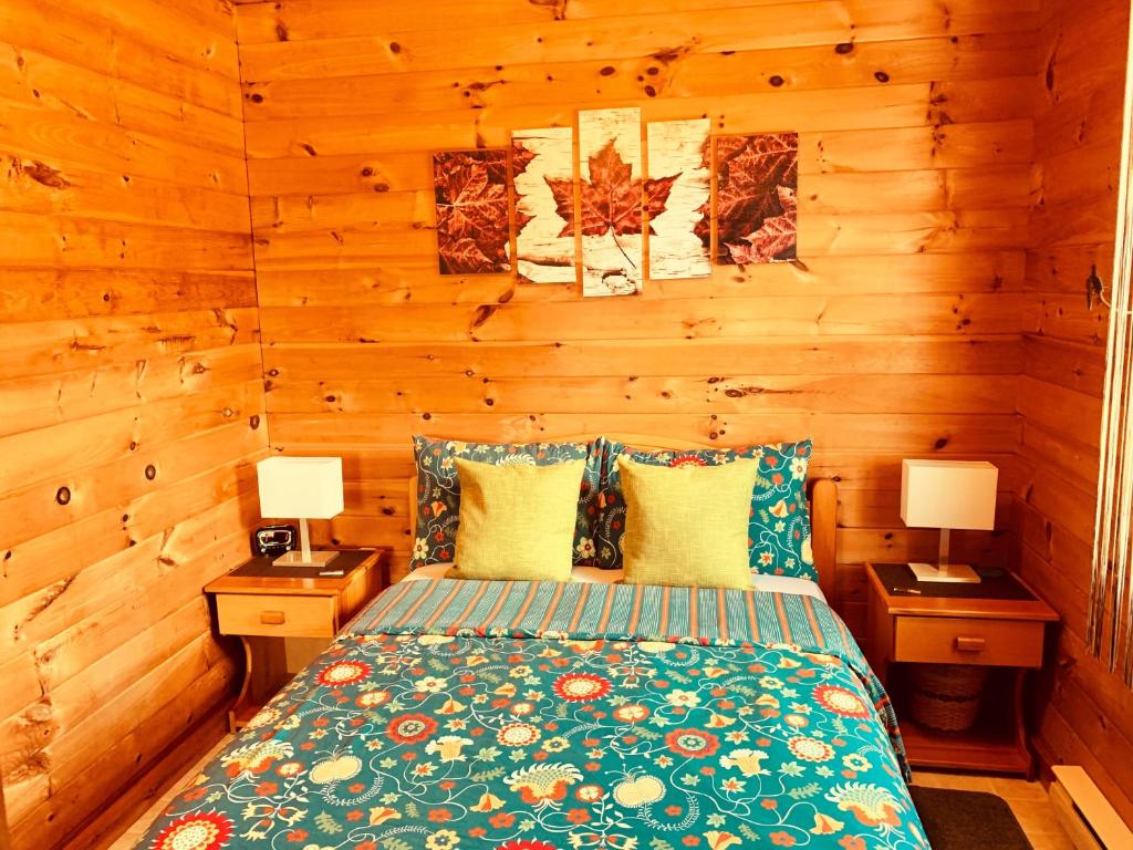 a bedroom with a bed with two night stands and two lamps at Eagle Valley Cottages in Queensport