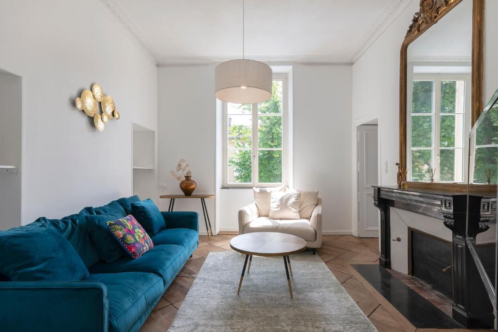 a living room with a blue couch and a fireplace at L'élégant de Stanislas in Nancy