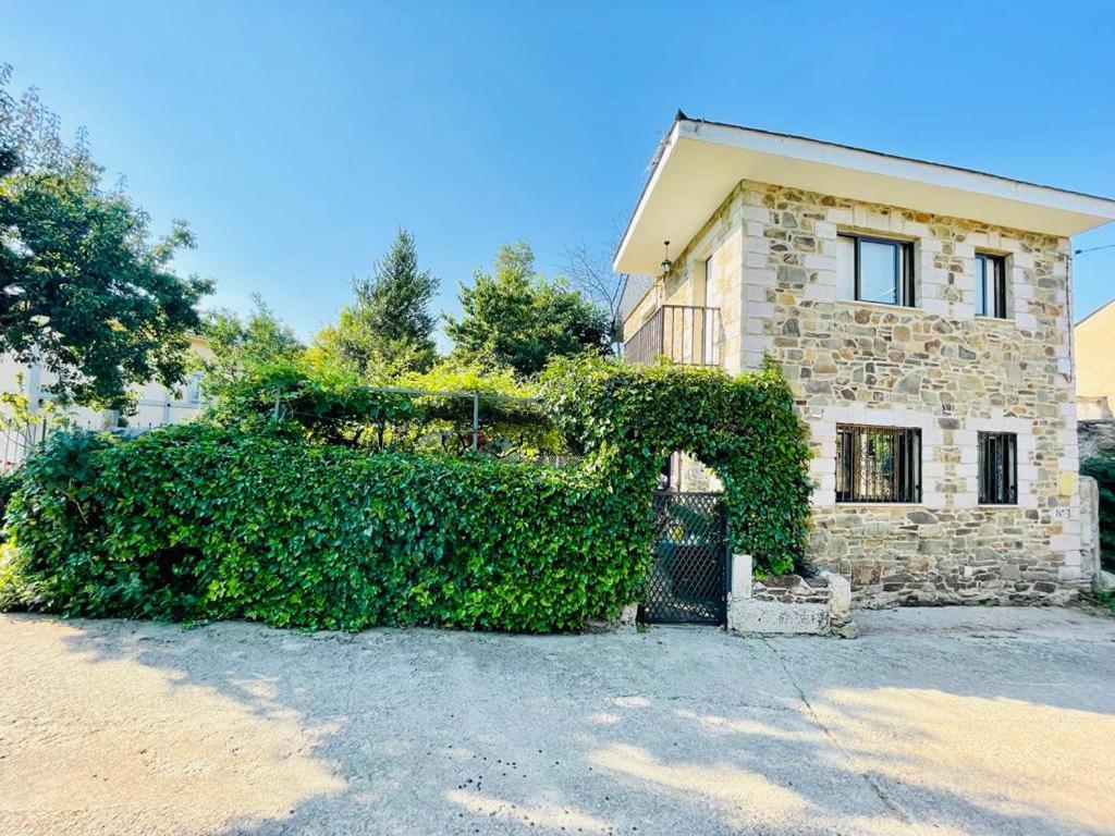 ein Gebäude mit einer großen Hecke davor in der Unterkunft Agradable casa con chimenea, en zona tranquila de Sanabria in Barrio de Lomba