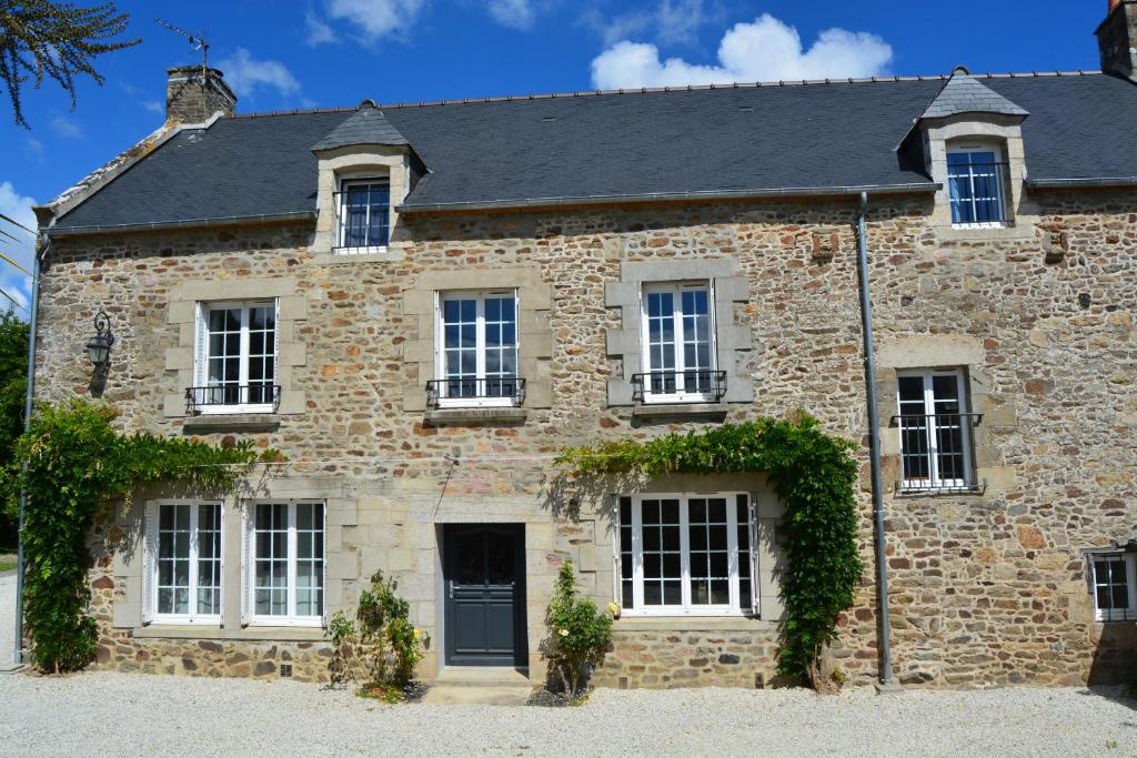 una vecchia casa in pietra con una porta nera di Lebeau Repos a Plouër-sur-Rance