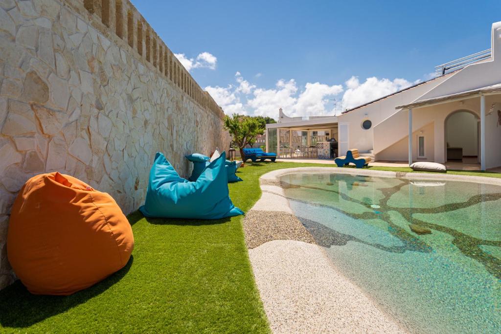 a swimming pool next to a wall next to a house at Don Leonardo - pool and wellness in Polignano a Mare