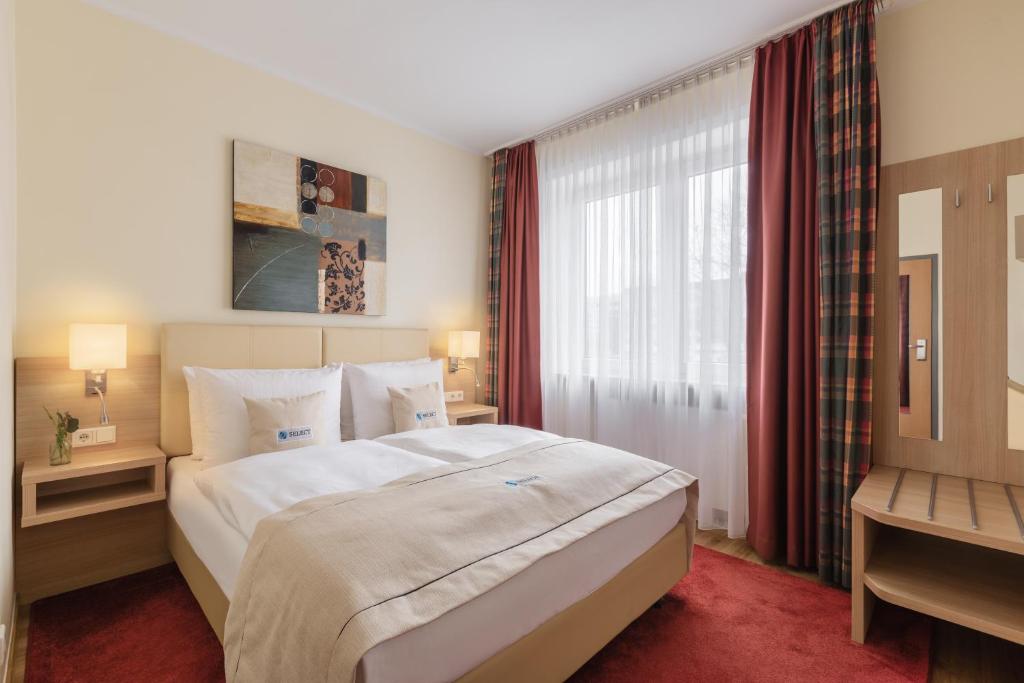 - une chambre avec un grand lit et une fenêtre dans l'établissement Select Hotel Tiefenthal, à Hambourg