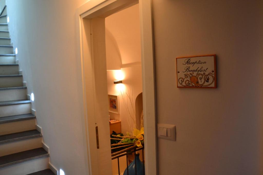 a hallway with stairs and a sign on the door at Terra Murata Boutique b&b in Procida