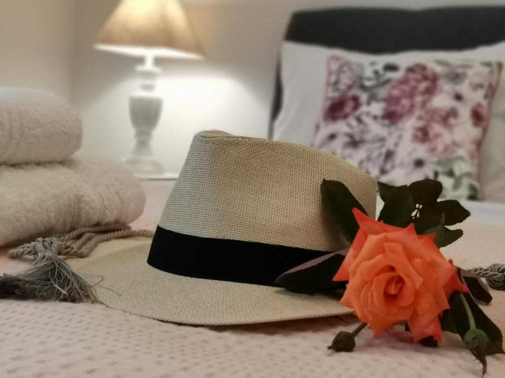 Un sombrero en una cama con una flor. en Nely's Luxury Home, en Nydri
