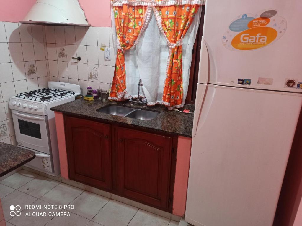 a kitchen with a sink and a refrigerator at Hospedaje El Turista. in Libertador General San Martín