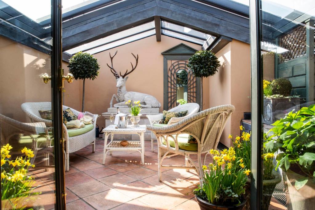 eine Terrasse mit Korbstühlen und einem Tisch in der Unterkunft Hazlitt's in London