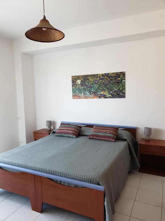 um quarto com uma cama e um quadro na parede em Baia Alcantara Apartments (Old Bay Group) em Giardini Naxos