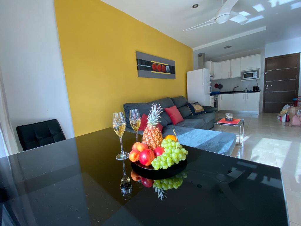 una sala de estar con una mesa con un bol de fruta. en SUNNY DAY 3 en Arguineguín