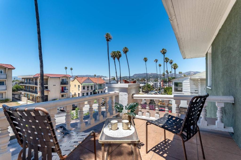 d'un balcon avec une table, des chaises et des palmiers. dans l'établissement Normandie Manor, à Los Angeles