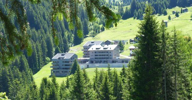 a large building on the side of a hill with trees at Apartment Typ D im Alpin Resort Mo in Gargellen
