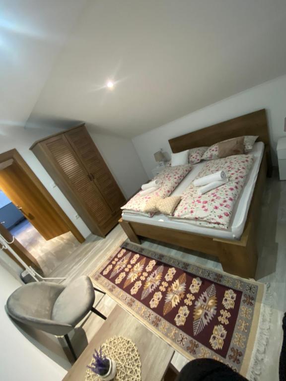 una camera con letto, sedia e tappeto di Apartman FILIP a Udbina