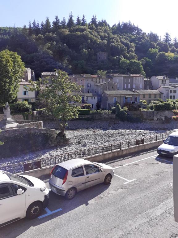 deux voitures garées sur le côté d'une route dans l'établissement charmant studio équipé au cœur du village, à Valleraugue
