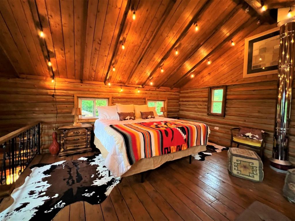 a bedroom with a bed in a wooden cabin at Li'l Ranch - Nature Lovers Retreat TEX MEX Log home in Wiarton