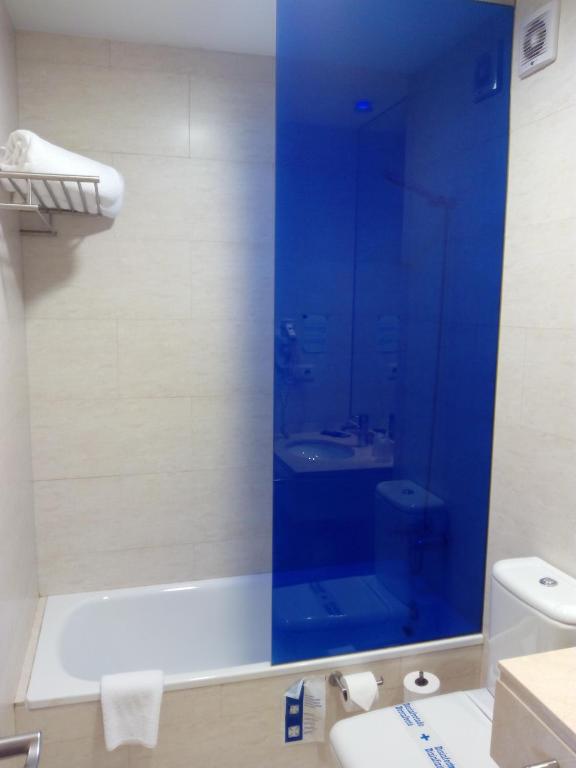 a bathroom with a glass shower with a toilet and a sink at Hotel Moon in A Coruña