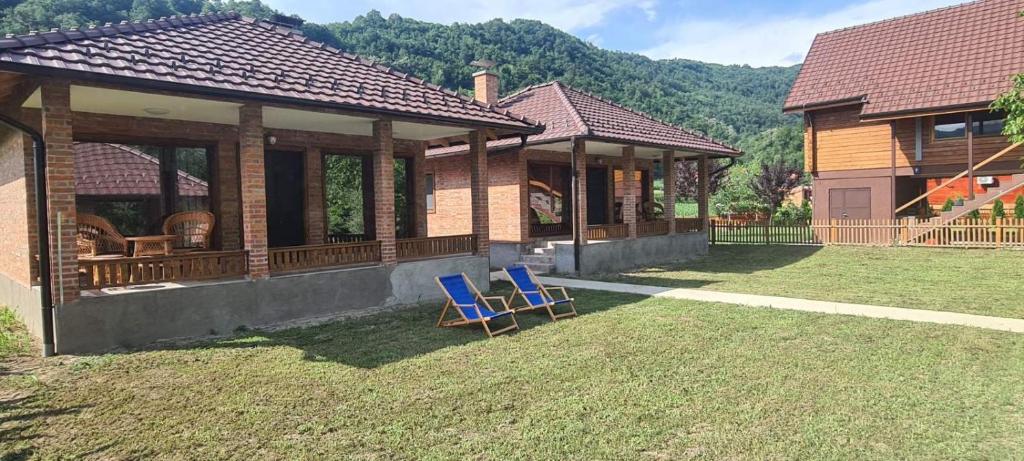 two blue chairs sitting outside of a house at Drinsko Srce in Ljubovija