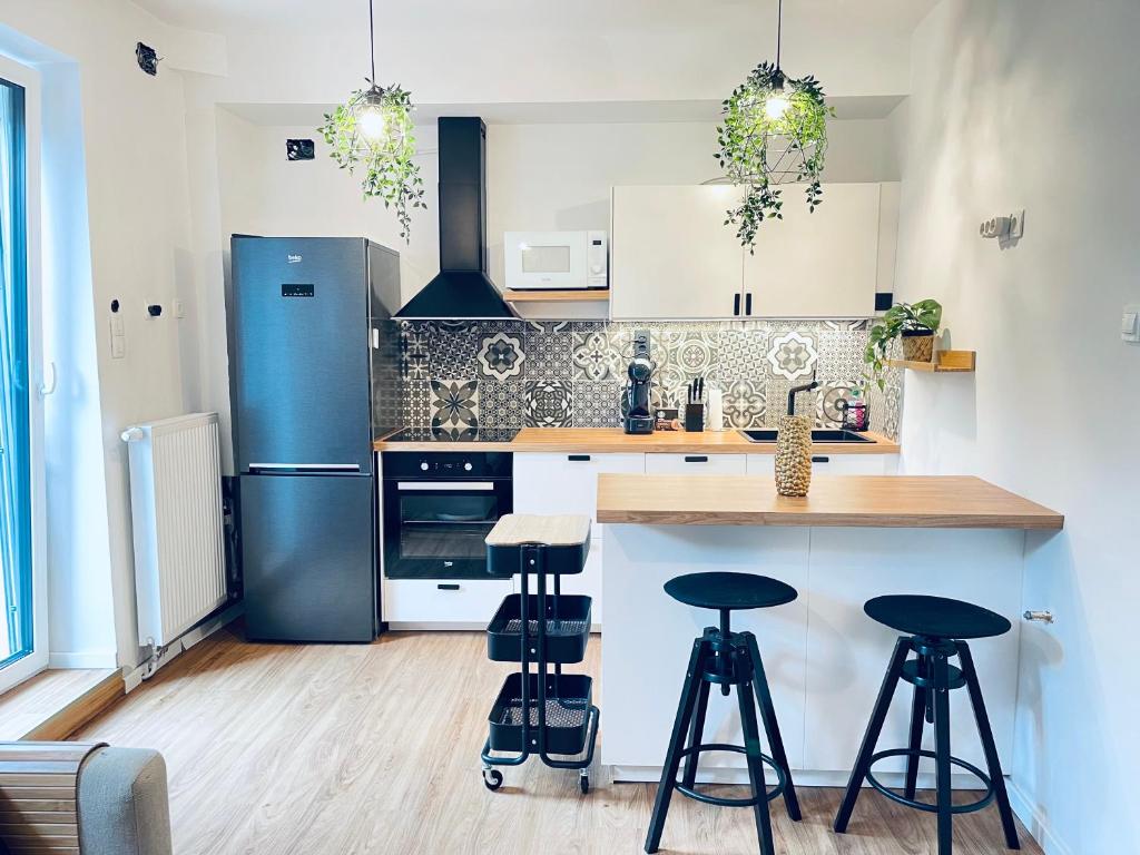 a kitchen with a blue refrigerator and bar stools at Apartma Naty in Ljubljana