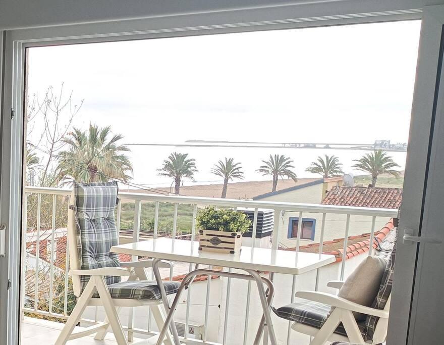 balcón con mesa, sillas y vistas al océano en Apartamento acogedor en primera linea de playa, en Denia