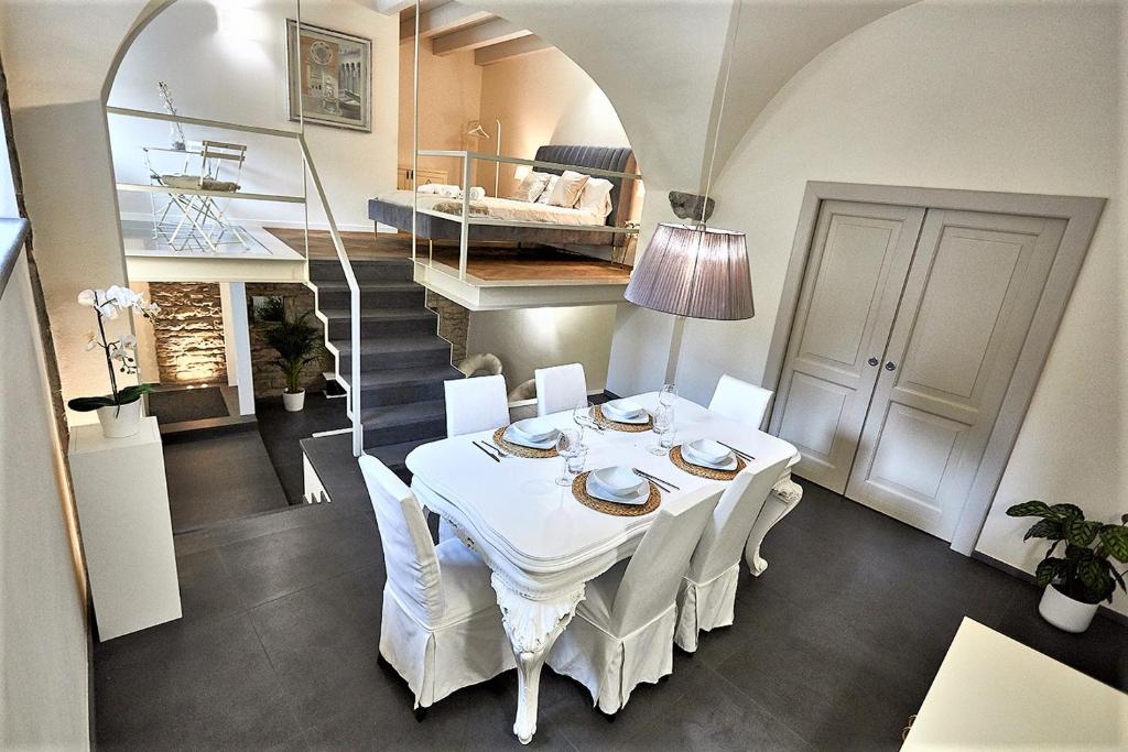 a dining room with a white table and white chairs at ASTRA-Modern Loft Cathedral View in Bergamo